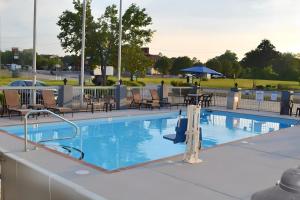 a large swimming pool with chairs and a table at Quality Suites Maumelle - Little Rock NW in Maumelle
