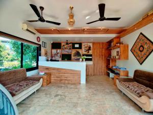 een woonkamer met 2 banken en een bar bij Lion Signature Family Resort in Sasan Gir
