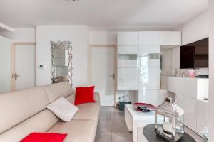 a living room with a white couch and red pillows at Superbe appartement à Decines in Décines-Charpieu