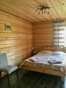 a bedroom with a bed in a log cabin at Котедж Шум Черемоша на березі річки in Verkhovyna