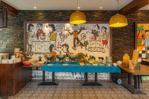 a table in a kitchen with a wall with a mural at Riva Gold Coast in Candolim