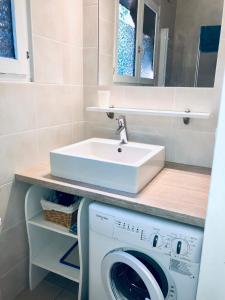 a bathroom with a sink and a washing machine at Chalet en Haute Savoie Location ski 2 appartements pour 6 ou 8 personnes Saint Gervais Les Bains in Saint-Gervais-les-Bains
