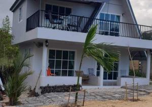 a white house with a balcony and a palm tree at Water Hill Resort 