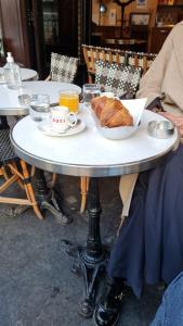 a table with a plate of bread and a cup of orange juice at 19 Atelier Montorgueil in Paris