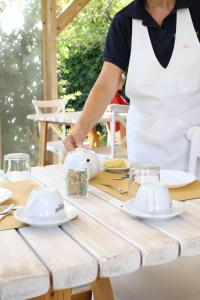 a woman in an apron standing over a wooden table at Agriturismo Fontanelle in Otranto +33 photos