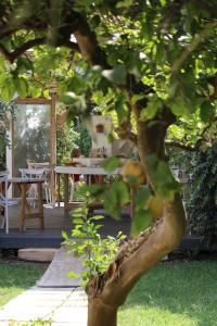 a tree in a garden with a table and chairs at Agriturismo Fontanelle in Otranto