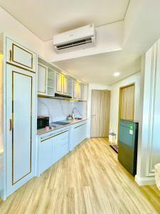 a kitchen with blue cabinets and a green refrigerator at Apartmen Sea View Lampung Mall 