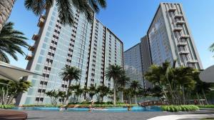 a large building with palm trees and a swimming pool at The Bay Apartemen Deluxe Lampung City Mall in Kuala