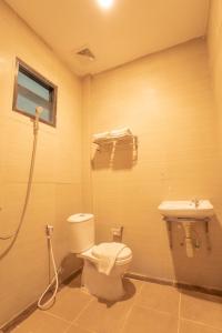 Livinn Hotel Kendangsari Surabaya في سورابايا: حمام مع مرحاض ومغسلة
