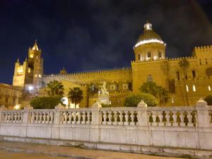 una recinzione di fronte a un edificio di notte di Casa PAN (Percorso Arabo Normanno) a Palermo