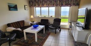 a living room with a couch and a table and chairs at Kind guesthouse - the village in Búðardalur