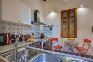 a kitchen with a sink and a table with red chairs at Rustico Pierino - Sweet Dreams in Florence in Florence
