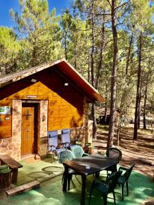 a patio with a table and chairs in front of a cabin at Casa Rural Campanilla in Riópar