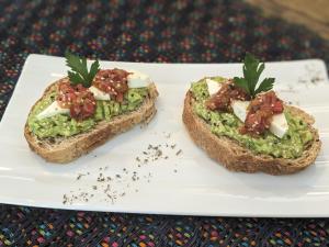 a white plate with two pieces of bread with guacamole at Perla de Fuego Casa de Huespedes in Barichara