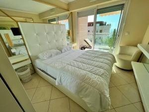 - une chambre avec un grand lit et un balcon dans l'établissement Les Jardins de Monaco vue mer et piscine, à Saint-Antoine