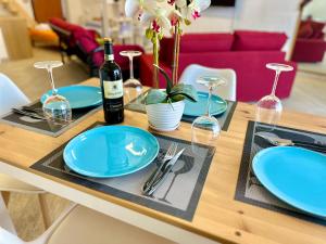 uma mesa de jantar com pratos azuis e copos de vinho em B&B The Loft em Gioiosa Ionica