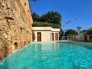 - une piscine sur le côté d'un bâtiment dans l'établissement Les Jardins de Monaco vue mer et piscine, à Saint-Antoine