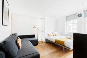 a living room with a bed and a couch at Hyde Park Apartments in London