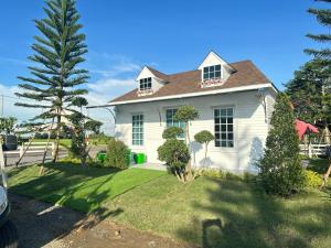 a white house with a tree in the yard at WHITE Houseรีสอร์ท in Ban Bung Thap Tae (1)