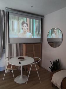 ein Wohnzimmer mit einem Flachbild-TV an der Wand in der Unterkunft Le Studio in Saint-Gilles