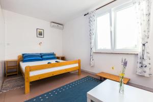 a bedroom with a bed and a window at Apartments Krizmanić in Ždrelac