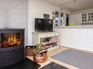 梅恩的住宿－6 person holiday home in Mern，客厅设有壁炉和电视。