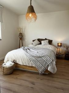 Charming house on the Luxembourg border في Messancy: غرفة نوم عليها سرير وبطانية