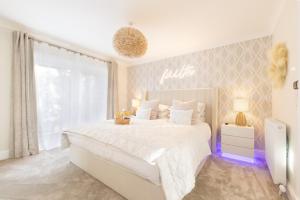 a white bedroom with a large bed and a window at The Koko Rooms in Inverness