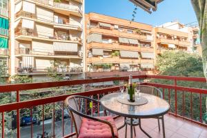a balcony with a table and chairs and a building at Confort Barcelona Rentals in Barcelona