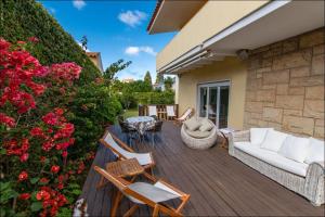 a wooden deck with a couch and chairs and flowers at Cascais Center Dream House in Cascais