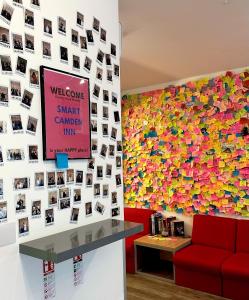 a wall of pictures on the wall of a waiting room at Smart Camden Inn Hostel in London