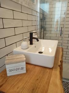 La salle de bains est pourvue d'un lavabo blanc sur un comptoir en bois. dans l'établissement La casetta di rosario mondello, à Palerme