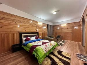 1 dormitorio con 1 cama y 1 silla en Hotel Tashi Ga Tsel, en Tawang