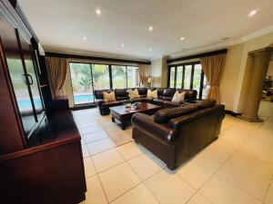 a large living room with a couch and a table at Palms On Byrne: Where Elegance Meets Serenity in Durban