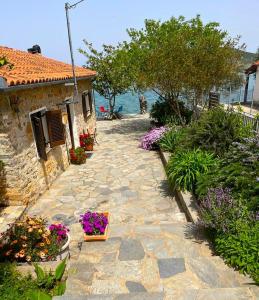 a stone walkway next to a house with flowers at Little Bit Of Heaven in Soúrpi
