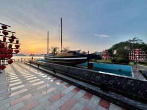 a boat is docked at a dock with the sunset at Phoenix Flower Hotel in Cat Ba