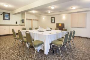 une salle de conférence avec une table et des chaises blanches dans l'établissement Super 8 by Wyndham Truro NS, à Truro