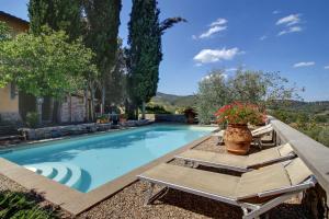 a swimming pool with a bench and flowers in a yard at Villa Stella - Homelike Villas in Figline Valdarno