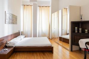 a bedroom with a bed and a mirror at Appartamento Gramsci by Wonderful Italy in Bologna