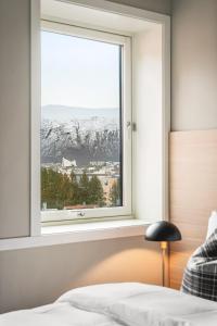 a bedroom with a window with a mountain view at Enter St Elisabeth Hotel & Spa in Tromsø