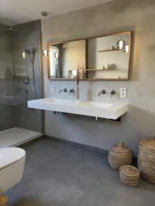 a bathroom with a sink and a mirror and a toilet at Charming house on the Luxembourg border in Messancy