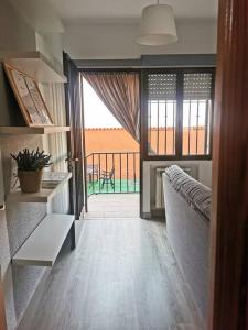 een woonkamer met een bank en uitzicht op een balkon bij El Nido VUT in Polán