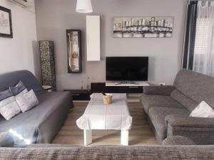 a living room with a couch and a tv at El Nido VUT in Polán