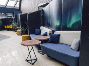 a room with two couches and two tables and the aururs at Novotel Arkhangelsk in Arkhangelsk
