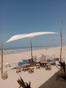 an umbrella and chairs and tables on the beach at Beach & Sunset villa in Mboro +62 photos