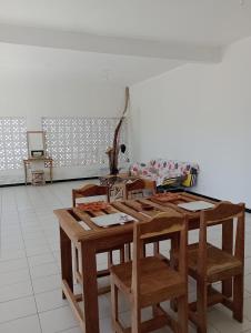 a wooden table and chairs in a room at Beach and sunset villa in Mboro