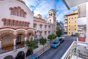 a view from the balcony of a building with a clock tower at Bright Apartment In Piraeus in Piraeus