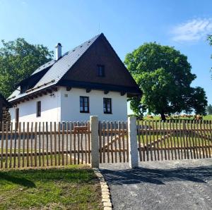 a white house with a wooden fence in front of it at Chaloupka Pomněnka na Lipce in Nasavrky