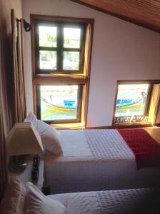 two beds in a room with two windows at SaberAmar Charme in Aveiro