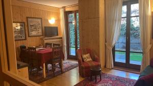 a living room with a desk and a chair and window at MONOLOCALE LA BORMINA in Bormio